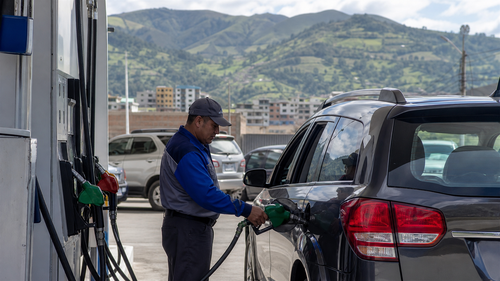 Tankwart betankt ein Auto an einer Tankstelle in Ecuador mit Andenlandschaft im Hintergrund