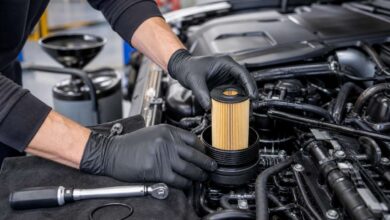 Mechaniker setzt einen neuen Ölfiltereinsatz in das Filtergehäuse eines Motors ein