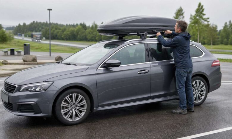 Fahrer prüft die Befestigung einer Dachbox auf einem Kombi