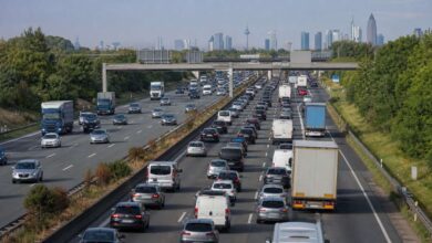 Dichter Auto- und Lkw-Verkehr auf der A5 mit Frankfurter Skyline im Hintergrund