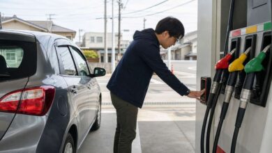 Tanken in Japan: Fahrer berührt vor dem Tanken die Anti-Statik-Fläche neben farbigen Zapfhähnen