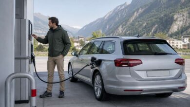 Reisender tankt einen Kombi an einer Tankstelle in Liechtenstein vor Alpenkulisse