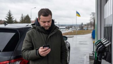 Autofahrer prüft an einer Tankstelle in der Ukraine aktuelle Warnhinweise