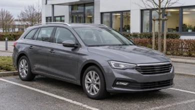 Grauer Firmenwagen auf einem Parkplatz vor einem Bürogebäude